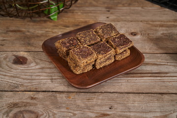 Brown sugar is placed in a wooden plate against the backdrop of a vintage old wooden board. Red ginger sugar blood food
