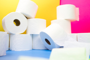 Stockpile of toilet paper rolls on colorful background. Many rolls at home in fear of corona virus...