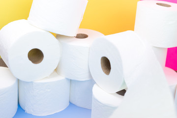 Stockpile of toilet paper rolls on colorful background. Many rolls at home in fear of corona virus...