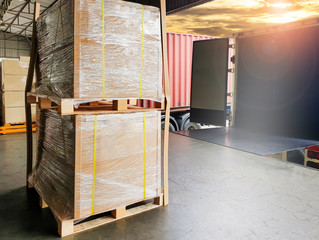Packaging Boxes Wrapped Plastic on Pallets Loading into Cargo Container. Shipping Trucks. Supply Chain. Shipment Boxes. Distribution Warehouse Freight Truck Transport Logistics.	