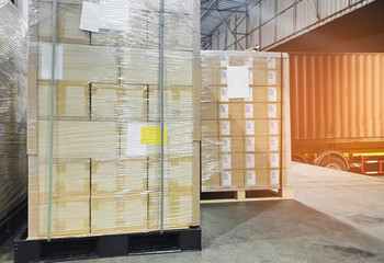 Packaging Boxes Wrapped Plastic on Pallet in The Warehouse. Trucks Loading Dock Warehouse. Distribution Center. Cargo Shipment. Supplies Warehouse. Shipping Trucks Logistics.	