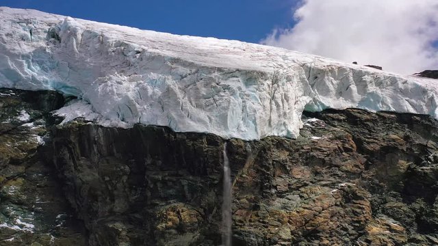 Aerial, pan, drone shot towards a waterfall, on the Monte Rosa glacier, in Aosta valley, Italy