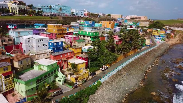 Aerial, rising, drone shot over a beach and colorful buildings in the La Perla area of San Juan, Puerto Rico, USA