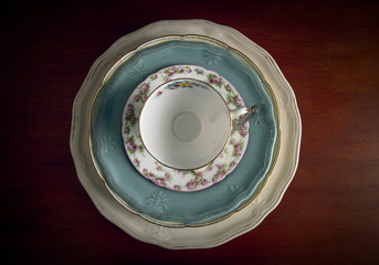 Vintage teacup, silver spoon, and plates piled up 