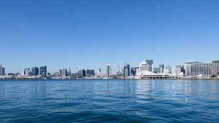 Fototapeta premium Budynki w Harumi Wharf i Shibaura Wharf widziane z Toyosu Wharf na tle błękitnego nieba