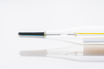 Mercury thermometer on the white medicine table. Selective focus. Shallow depth of field. Macro shot.