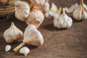 Garlic cloves and garlic on an old wooden table