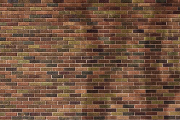 Patchwork design vintage brick wall texture background with colorful natural earth tone shades, showing subtle tree shadows from low angle sunlight