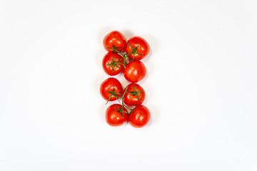 Red tomatoes on a branch on a white background, top view