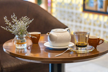 Ceramic tea pot and mug on round coffee table 