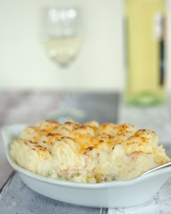 fish pie served with a glass of white wine