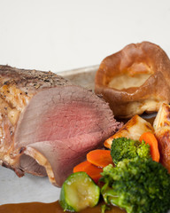Beef sunday lunch served with vegetables and yorkshire puddings