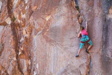 A girl climbs a rock.
