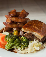 steak and ale pie served with thick cut chips and vegetables