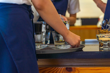 Closeup photo of waitress hands serving Vietnamese styled dripping coffee