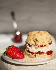 Date and walnut scone served with whipped cream and strawberry jam