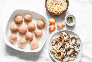 Ingredients for cooking orzo mushrooms pasta with teriyaki sauce chicken roasted meatballs on a light background, top view