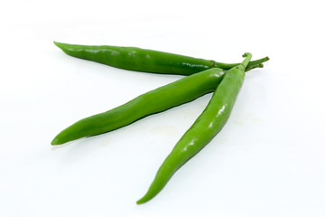 bunch of fresh green chili peppers on a white background
