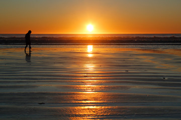 Silhouette of woman on beach at sunset