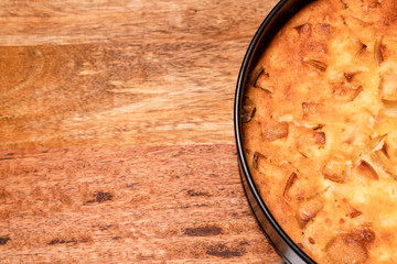 fragment of homemade cake in pan on wooden Board. 