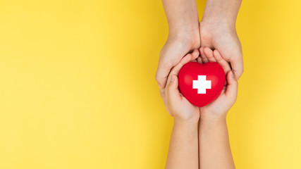 world red cross day, adult and child hands holding red heart, healthcare, love and family insurance...