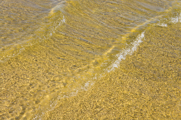Sandy bottom of a river shot on a sunny spring day. Background for clear water.