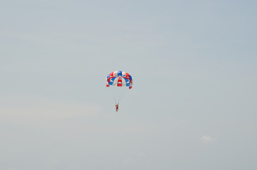 Man on a parachute flying in the sky in summer vacation
