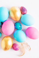 Fototapeta na wymiar Happy easter concept. Big small eggs of various fashionable colors lie in a heap on a white background. Copy space