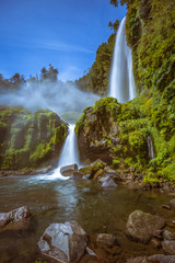 Obraz premium Beautiful Patagonian waterfall in a forest lit by the rising sun of Patagonia