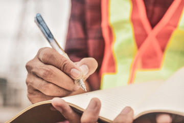 Close up technician writing on note book