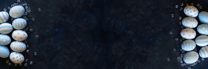 Easter banner background with polka dots and stripes blue eggs on dark textural background with beads. Spring Festive design. Top view with copy space