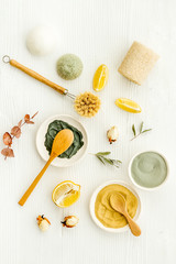 Clay mask, natural facial cosmetic set with herbals on white background - top view