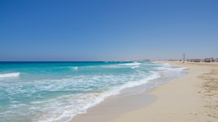 Fototapeta na wymiar Marsa Matruh, Egypt. The sandy beach and the amazing sea with tropical blue, turquoise and green colors. Relaxing context. Fabulous holidays. Mediterranean Sea. North Africa. Clean and pristine sea