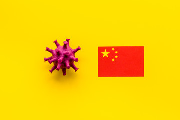 Concept of Corona virus Covid-19 with chinease flag on yellow background top-down