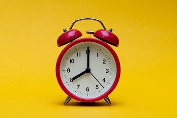 Close up red alarm clock on yellow background