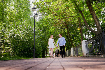 Young man and woman couple walk in the park. Spring or summer love story. Young happy family