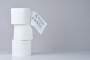 Consumer buying panic about coronavirus covid-19 concept. Toilet paper rolls with word stop panic
