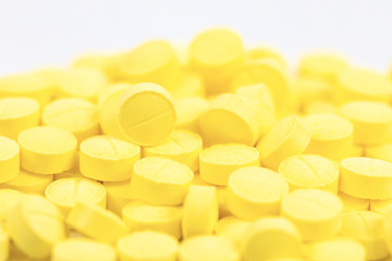 Fototapeta na wymiar Selective focus of yellow medicine pills on white background.