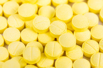 Selective focus of yellow medicine pills background.