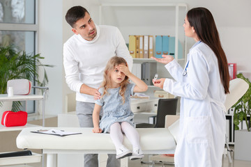 Man with little daughter visiting pediatrician in clinic