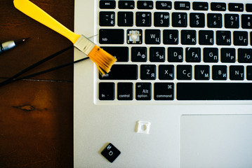 screwdriver and spare parts from a laptop. Keyboard, brush, keys. Laptop repair