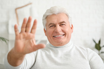 Senior man video chatting at home