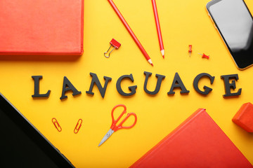 Composition with stationery and text LANGUAGE on color background