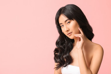 Fototapeta premium Young Asian woman with beautiful long hair on color background