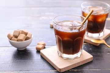 Glasses of tasty cold coffee and sugar on table