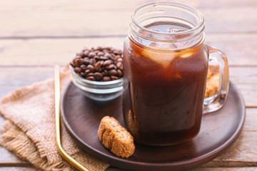 Mason jar of tasty cold coffee on table