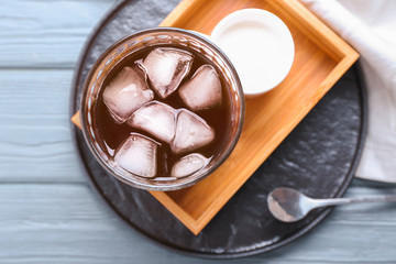 Glass of tasty iced coffee on table