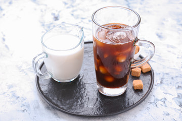 Tasty iced coffee and milk on table