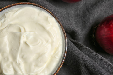 Bowl of tasty sour cream on table, closeup