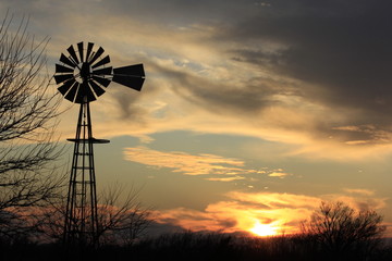 Kansas colorful Sunset with a Windmill silhouette out in the country.